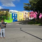 Chérif Keïta standing in front of a row of colorful houses.